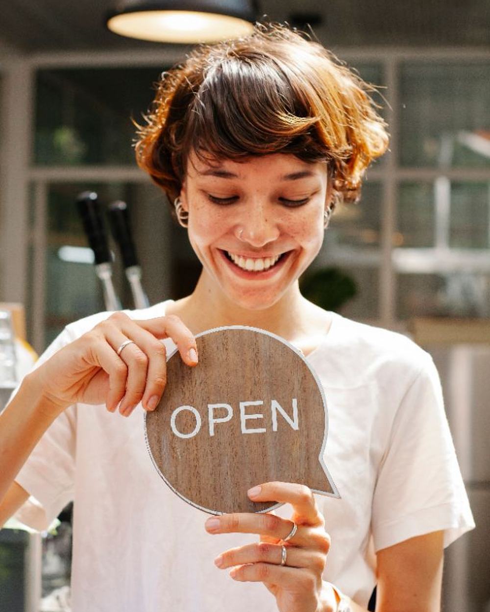 An owner turning the sign to open